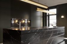 10 an exquisite black kitchen with plain cabinets and an oversized black marble kitchen island plus touches of gold