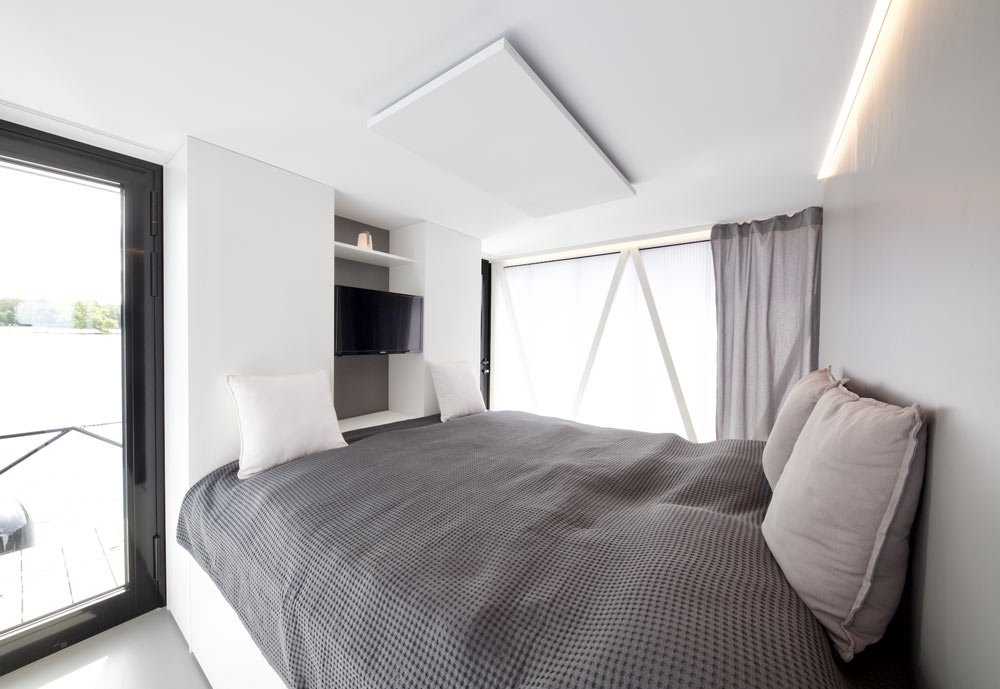 The bedroom features a comfy bed, glazings and a built in TV on the wall