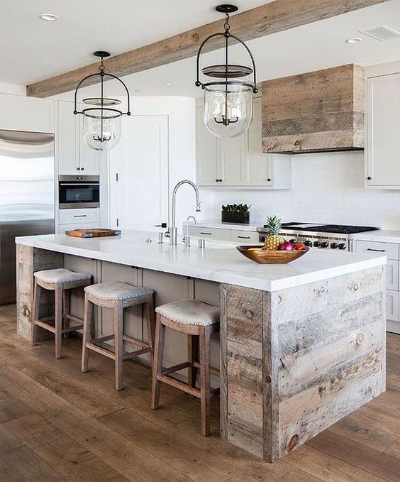a neutral modern farmhouse kitchen with statement glass and metal lights over the kitchen island
