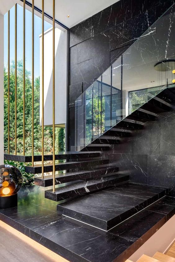 a black marble wall and a matching floating staircase make the layout luxurious and very chic