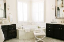 19 a refined white bathroom with a white marble floor, black furniture, a crystal chandelier and statement mirrors
