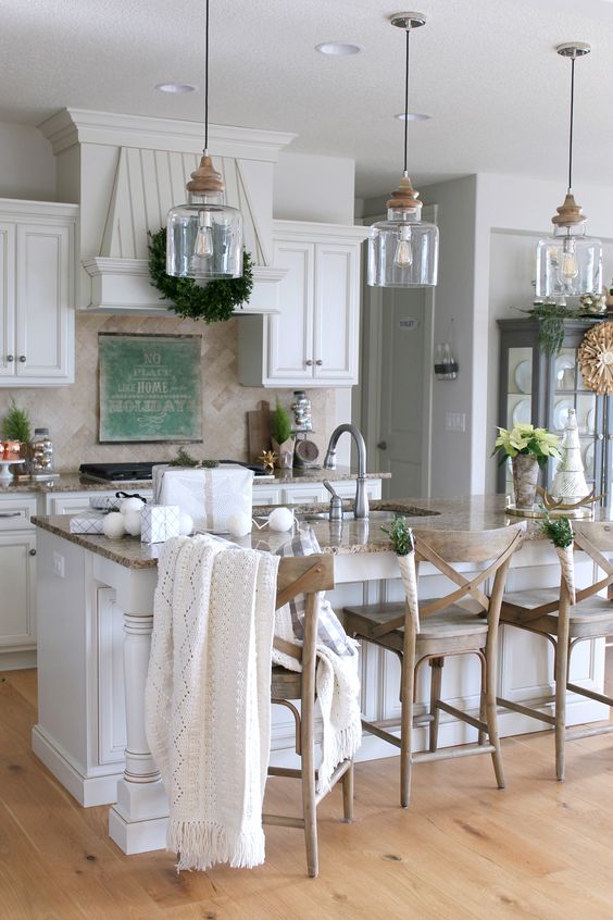 a cozy farmhouse kitchen with a row of glass and wood pendant lamps over the kitchen island