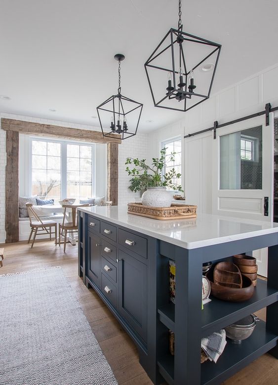 a navy kitchen island that includes an open storage space and some drawers, too