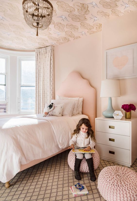 a blush girl's bedroom accented with printed wallpaper on the ceiling looks more interesting and dreamy
