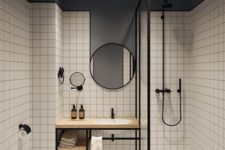 a grey and white bathroom accented with black edges, fixtures and mirror frames looks more modern and bolder