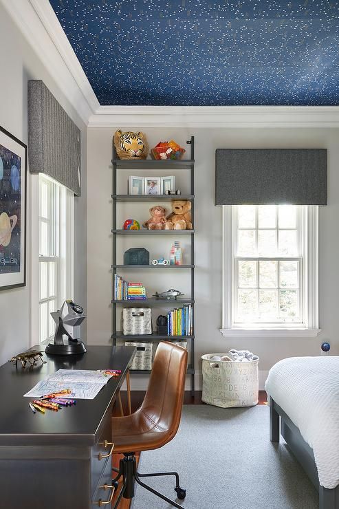 a kid's room with a navy celestial wallpaper ceiling that makes the space more dreamy and beautiful