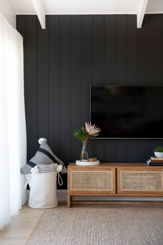 a neutral living room with a black beadboard wall for a bold and contrasting statement in the interior