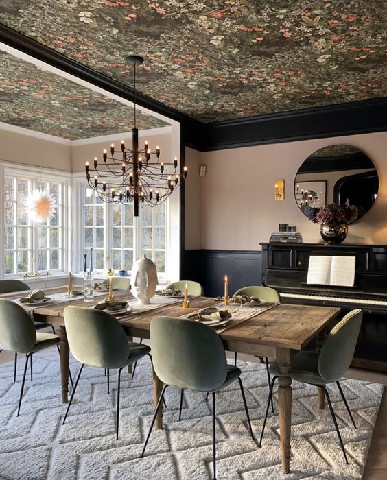a refined dining room with a dark floral wallpaper ceiling that echoes with the chairs in color