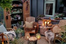 a small backyard with a wardrobe used as a plant stand, wooden and rattn chairs, candle lanterns, a tree stump and some jute rugs