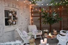 a small eclectic backyard with a fire pit, some white vintage furniture and lights all over the space