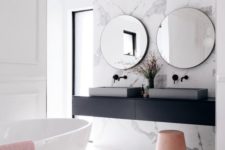 a stylish contemporary bathroom with a black floating vanity and black fixtures plus softening blush touches