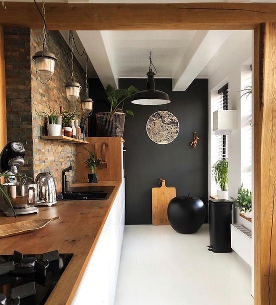A stylish kitchen with a black accent wall, a statement apple as an art object and black appliances looks wow