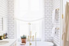 a vintage black clawfoot bathtub and black grout with subway tiles bring more chic to the space