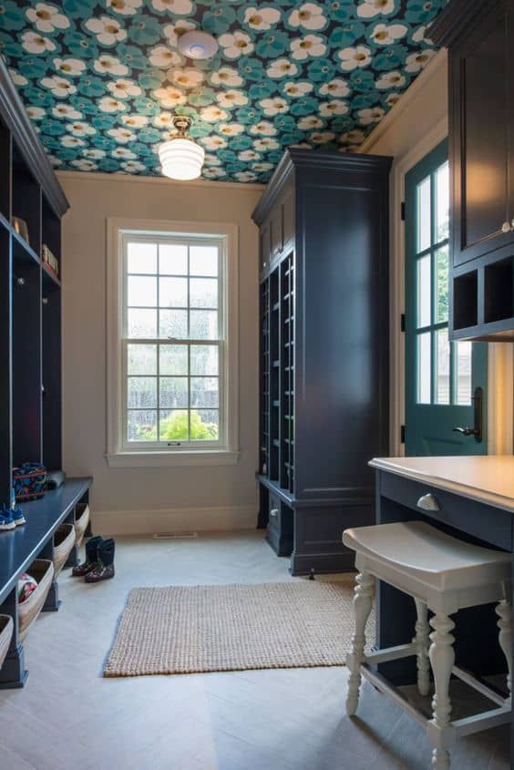 a vintage mudroom with a floral print wallpaper ceiling that adds print to the space and makes it chic