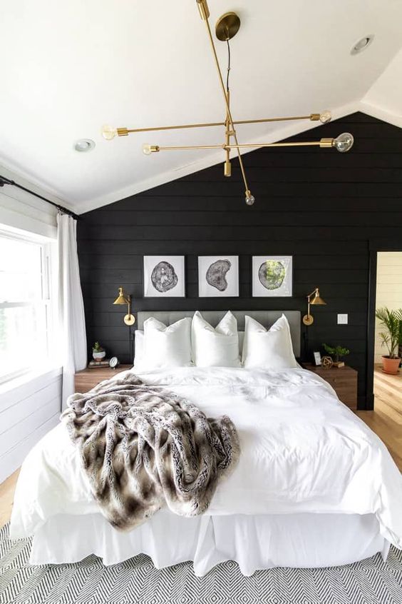 a welcoming master bedroom in neutrals, with a black accent wall, neutrals all over and touches of gold and brass