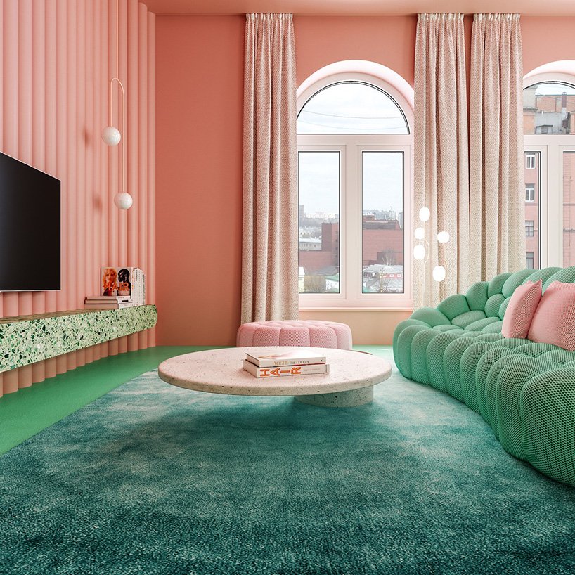 The living room is done with pink walls and an ottoman and all the rest done in green