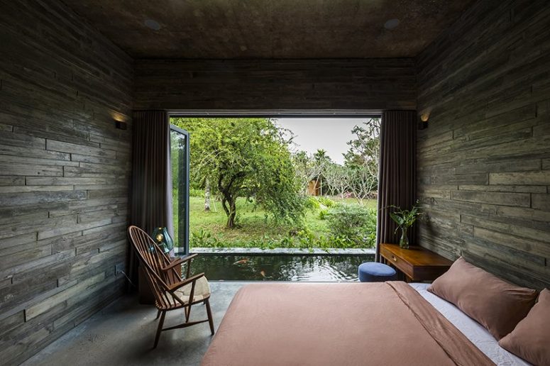 The bedroom features woodgran concrete boards covering it completely, a glazed wall that can be opened as a door to the pond and comfy furniture for sleeping