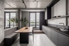03 The kitchen is done with sleek grey cabinets, a stylish dining zone with built-in benches and a table and dark linens