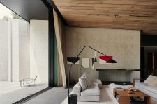 03 The living room features a concrete wall, a fireplace, a wooden ceiling and comfy furniture