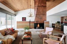 03 The living room shows off a gorgeous copper clad fireplace on stone, stylish furniture and layered rugs