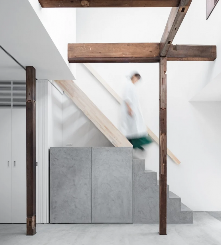 The staircase features a built-in grey storage unit under it to make use of this awakward space