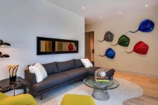 06 A second mini living room is done with elegant furniture, bright mustard pieces and colorful artworks on the wall