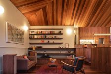 08 The living room shows off cool floating shelves that echo with the wooden clad ceiling