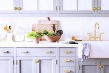 a cute lilac kitchen with a white tile backsplash and elegant gold handles looks very stylish and non-typical
