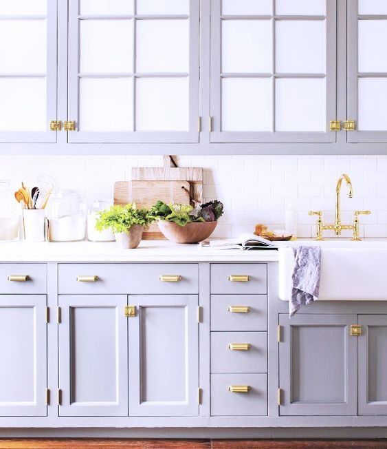 A cute lilac kitchen with a white tile backsplash and elegant gold handles looks very stylish and non typical