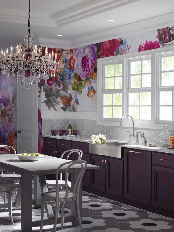 a refined purple kitchen with marble hex tiles, an oversized bright floral artwork and a crystal chandelier