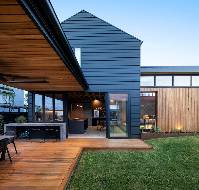 The house shows off a kitchen and dining space that can be opened to outdoors with sliding doors and an additional meal zone outdoors but under a roof