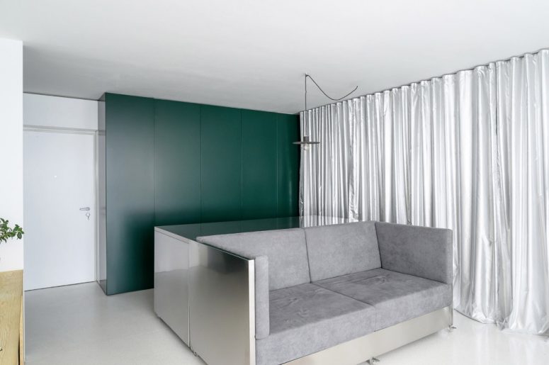 The sofa is also done with stainless steel, and the storage unit is sleek, in hunter green