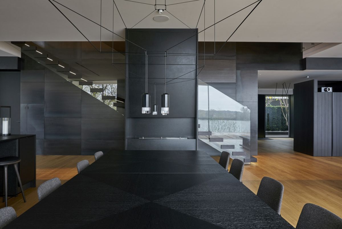 The kitchen and dining space are done in black, with contemporary lamps and bold design