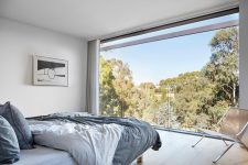 06 The master bedroom features a glass wall with views and minimal furniture