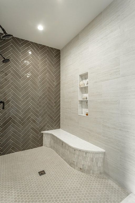 There's a large walk-in shower done with three different types of tiles