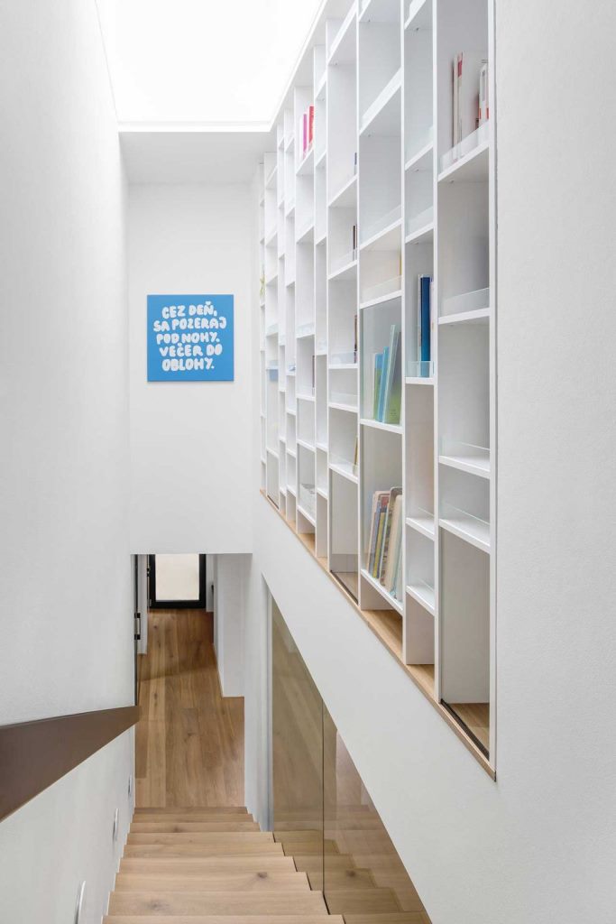 A giant bookshelf is placed over the stairs to use this awkward space, too