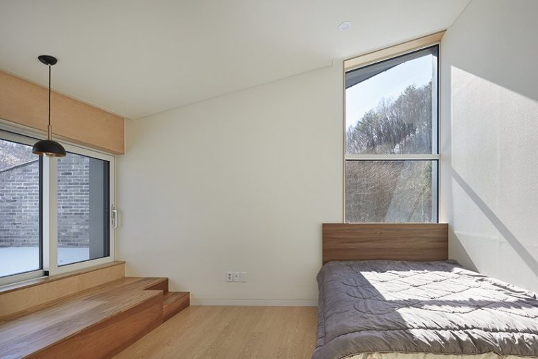 The bedroom is minimal, with a bed and some storage units and light plus lots of windows for the views
