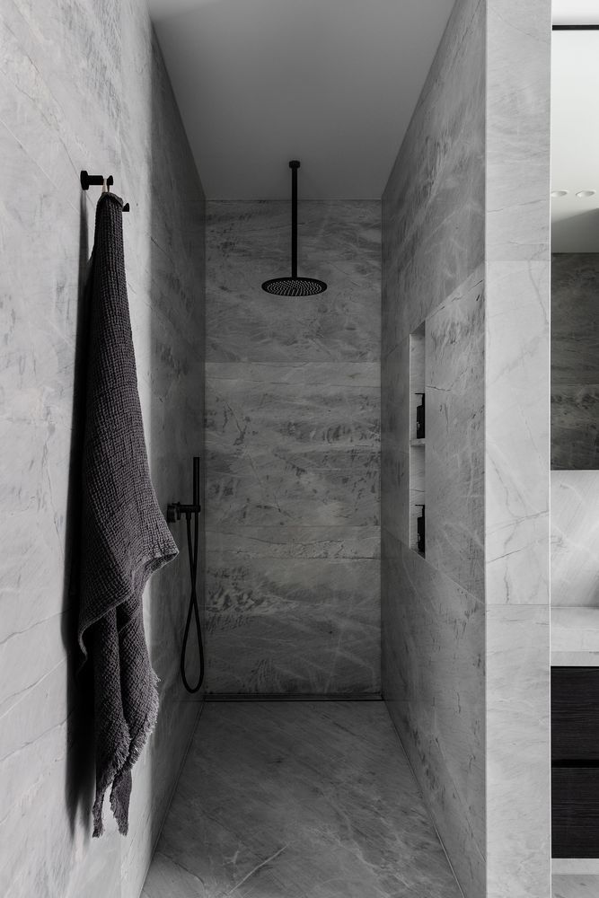 Soft grays create a calming and relaxing ambiance in this open walk-in shower