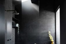 10 The black bathroom combines black penny and subway tiles and features windows