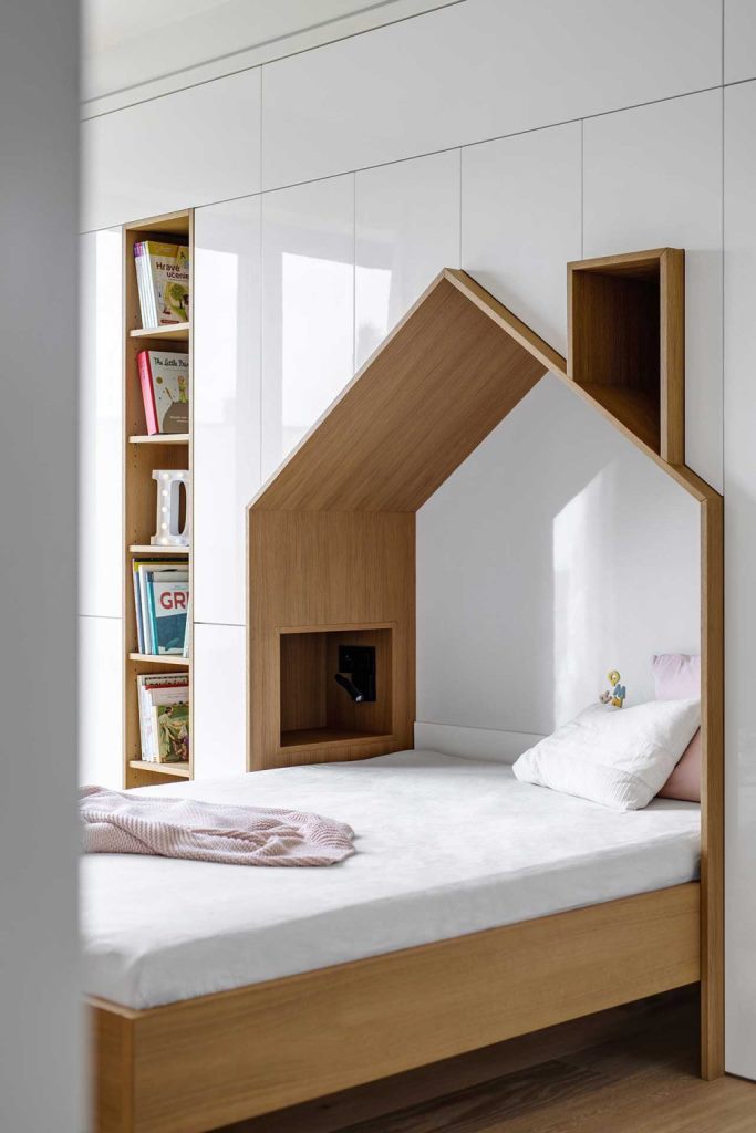 The kid's room shows off a house-shaped bed with much storage space included