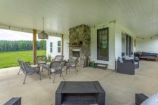 14 A large covered patio features a stone fire[;ace and woven furniture