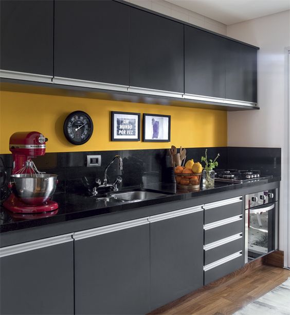 a bold graphite grey kitchen with a black and yellow backsplash and black stone countertops