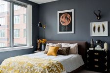 a chic bedroom with graphite gray walls, a brown bed, mismatching nightstands, yellow linens and printed textiles
