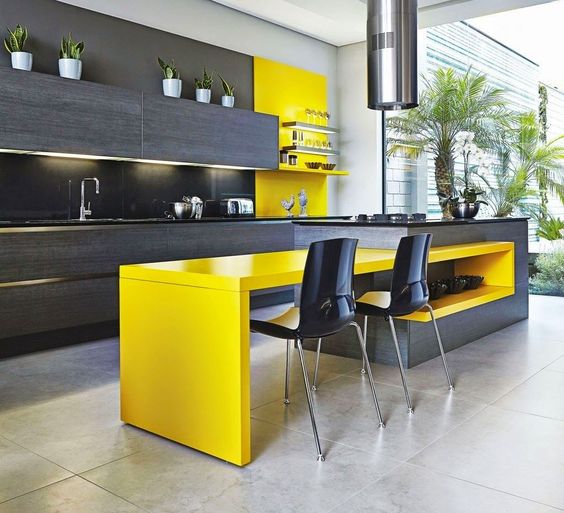 a chic kitchen with dark grey wooden cabinetry, a matching kitchen island with a bright yellow table and a backsplash