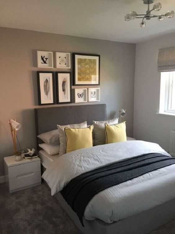a modern dove grey bedroom with a grey bed, grey and yellow linens, a grey and yellow gallery wall