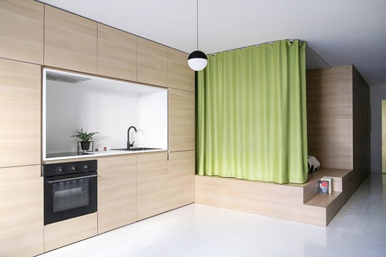 The apartment is an open space divided into zones with a lime curtain