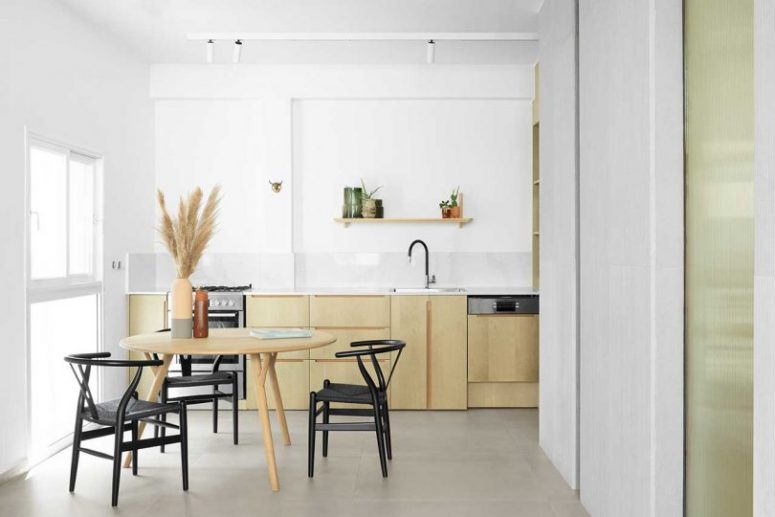 The kitchen is neutral, with white tiles, a stylish table and black chairs, everything is cool and chic