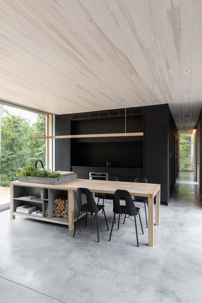 The kitchen is done in black, there's a wood and stone kitchen island that doubles as a dining table