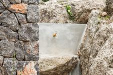 04 The sink is carved of stone outdoors and it features an elegant gold faucet