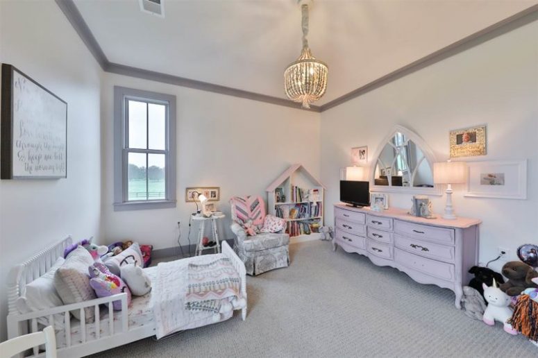 The kid's room is soft and pastel, with chic vintage furniture and a beautiful blush sideboard